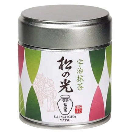A cylindrical metal tin of Uji Matcha from the brand Shohokuen, featuring a silver lid and a label with green, white, and pink geometric patterns and Japanese text.